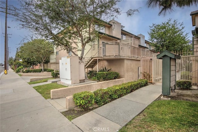 1211 E Carson St Unit 27, Carson, CA 90745 - view of home's exterior with stairs and stucco siding