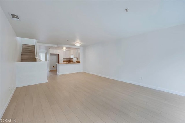 1211 E Carson St Unit 27, Carson, CA 90745 - unfurnished living room featuring stairway and light wood finished floors