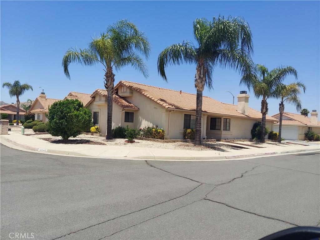 view of front of property with stucco siding, a tile roof, and a chimney