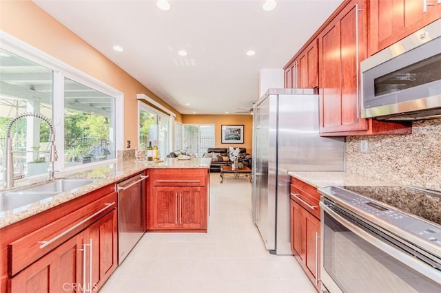 2771 Wyckersham Pl, Fullerton, CA 92833 - kitchen with appliances with stainless steel finishes, light tile patterned flooring, tasteful backsplash, light stone countertops, and open floor plan