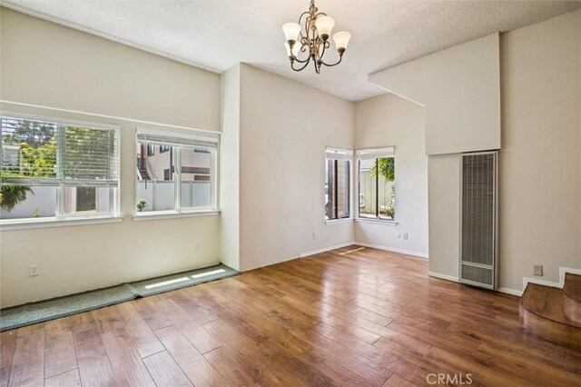 1263 Pismo St, San Luis Obispo, CA 93401 - unfurnished room featuring a heating unit, a chandelier, and wood-type flooring