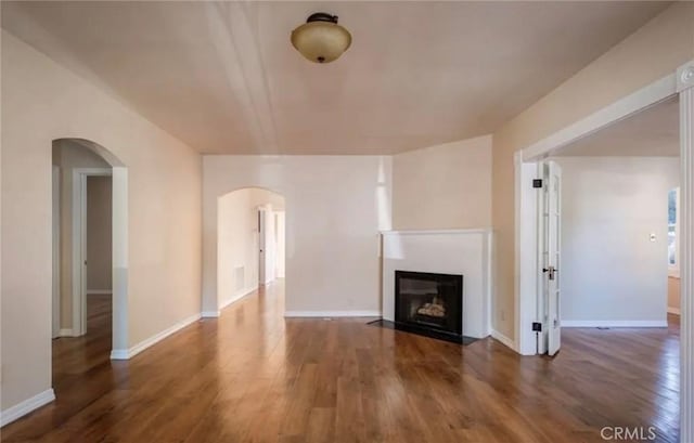 1263 Pismo St, San Luis Obispo, CA 93401 - unfurnished living room with arched walkways, wood finished floors, and a fireplace with flush hearth