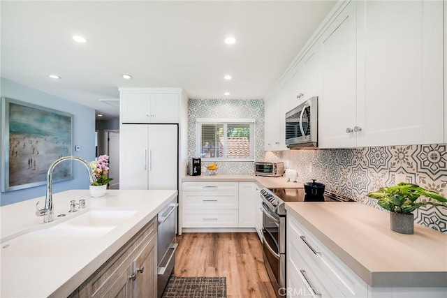5490 Paseo Del Lago W Unit P, Laguna Woods, CA 92637 - kitchen with stainless steel appliances, decorative backsplash, light countertops, white cabinetry, and recessed lighting