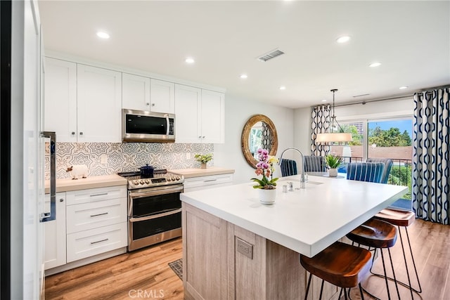 5490 Paseo Del Lago W Unit P, Laguna Woods, CA 92637 - kitchen with appliances with stainless steel finishes, light wood-type flooring, light countertops, tasteful backsplash, and recessed lighting