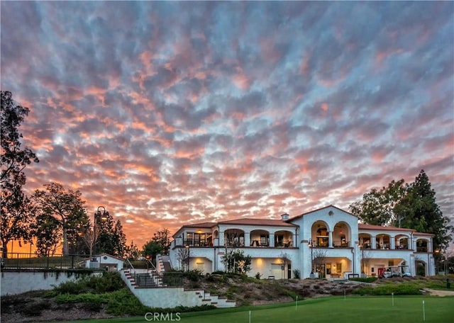 5490 Paseo Del Lago W Unit P, Laguna Woods, CA 92637 - back of house at dusk featuring a putting green and a balcony