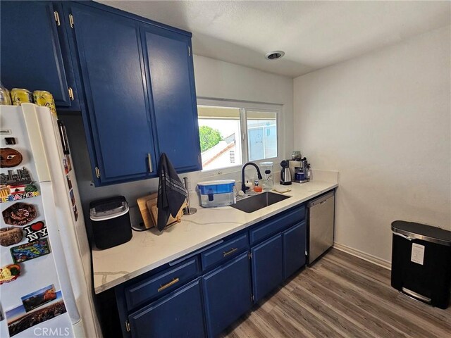 874 Cinnamon Ln Unit 62, Duarte, CA 91010 - kitchen featuring freestanding refrigerator, blue cabinetry, stainless steel dishwasher, dark wood finished floors, and light stone countertops