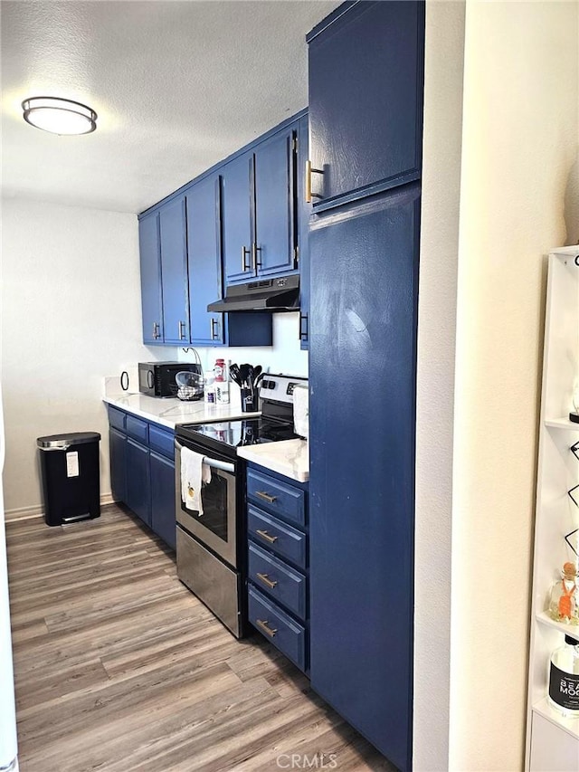 874 Cinnamon Ln Unit 62, Duarte, CA 91010 - kitchen featuring blue cabinetry, stainless steel range with electric cooktop, under cabinet range hood, light wood-style floors, and light countertops