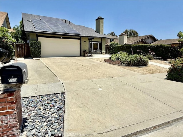 1171 Silverfern Ln, Corona, CA 92878 - ranch-style home with solar panels, a garage, concrete driveway, a chimney, and stucco siding