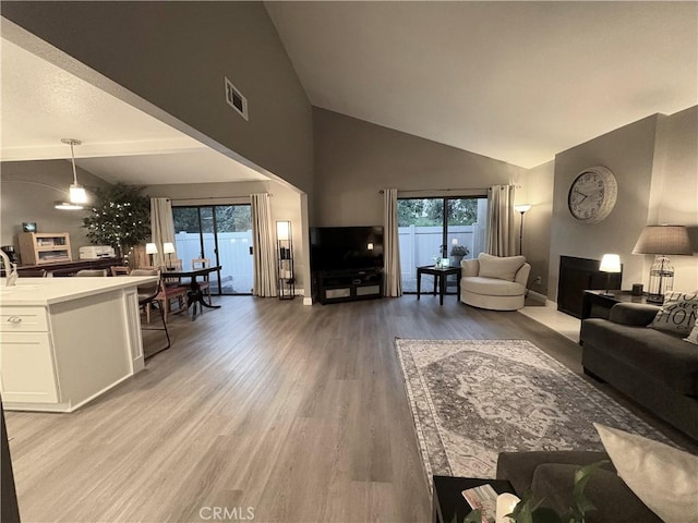 1137 Mountain Gate Rd, Upland, CA 91786 - living area with light wood finished floors, high vaulted ceiling, and healthy amount of natural light