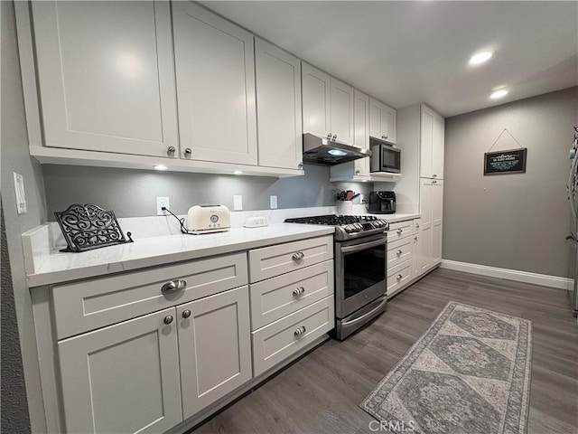 1137 Mountain Gate Rd, Upland, CA 91786 - kitchen with appliances with stainless steel finishes, under cabinet range hood, dark wood-style floors, light countertops, and white cabinets