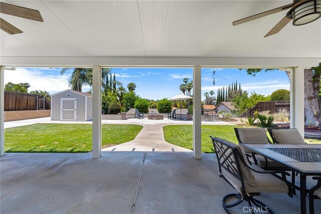 6095 Windemere Way, Riverside, CA 92506 - fenced backyard featuring a patio, a ceiling fan, a storage unit, and outdoor dining space