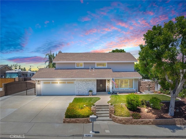 6095 Windemere Way, Riverside, CA 92506 - traditional home with a tile roof, concrete driveway, a gate, a garage, and stone siding