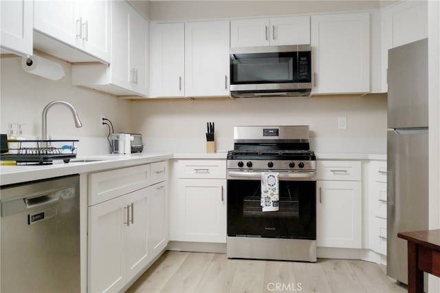 1034 Occidental Cir, Redlands, CA 92374 - kitchen featuring appliances with stainless steel finishes, light countertops, white cabinets, and light wood finished floors