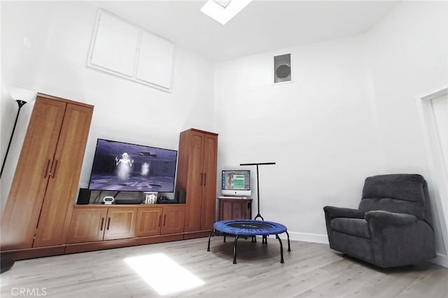 1034 Occidental Cir, Redlands, CA 92374 - living area featuring light wood-style floors, a skylight, and a towering ceiling