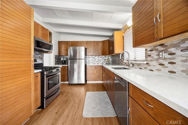 18101 Kirk Ave, Tustin, CA 92780 - kitchen featuring appliances with stainless steel finishes, light wood-type flooring, decorative backsplash, beamed ceiling, and light countertops