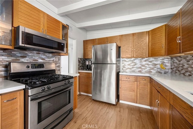 18101 Kirk Ave, Tustin, CA 92780 - kitchen with appliances with stainless steel finishes, light wood-style floors, beamed ceiling, brown cabinetry, and backsplash