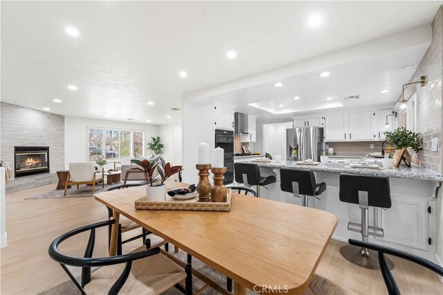 41901 Calle Clarita, Lancaster, CA 93536 - dining area with a fireplace, light wood-style flooring, and recessed lighting