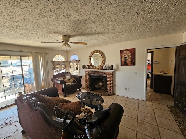 16709 Deodar St, Hesperia, CA 92345 - living room featuring ceiling fan, tile patterned flooring, a brick fireplace, and a textured ceiling
