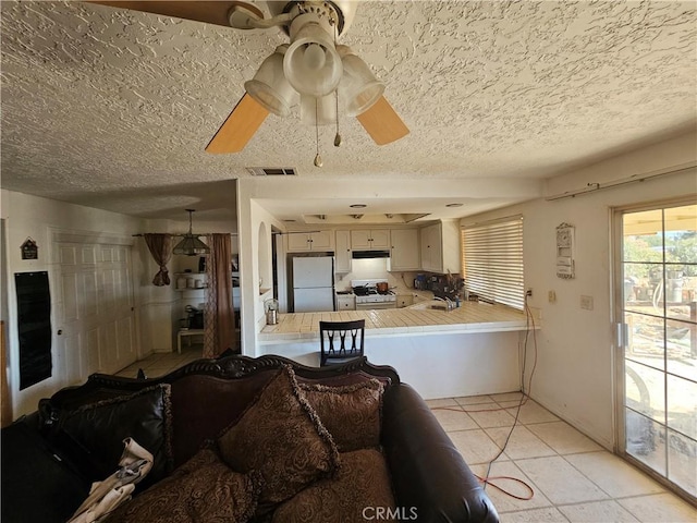 16709 Deodar St, Hesperia, CA 92345 - living area with a textured ceiling, light tile patterned floors, and a ceiling fan