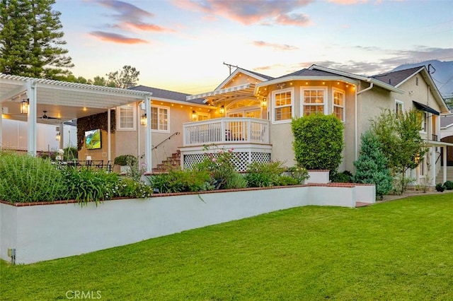 3326 Los Olivos Ln, Glendale, CA 91214 - back of house at dusk with stucco siding, a pergola, a lawn, a wooden deck, and stairs