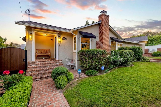 3326 Los Olivos Ln, Glendale, CA 91214 - view of front of property featuring stucco siding, a chimney, a front lawn, and a gate