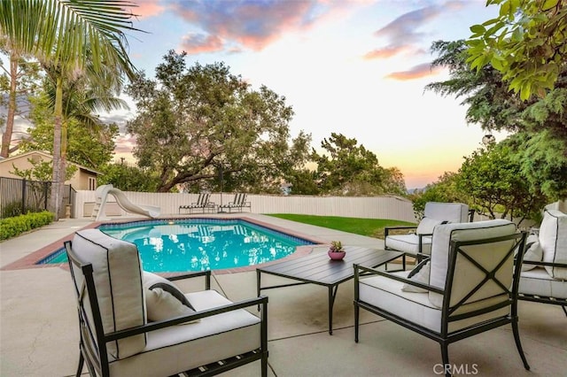 3326 Los Olivos Ln, Glendale, CA 91214 - pool at dusk with a water slide, an outdoor hangout area, a fenced backyard, and a patio area