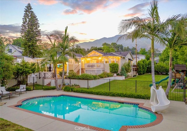 3326 Los Olivos Ln, Glendale, CA 91214 - pool at dusk with a water slide, a mountain view, a playground, and a patio