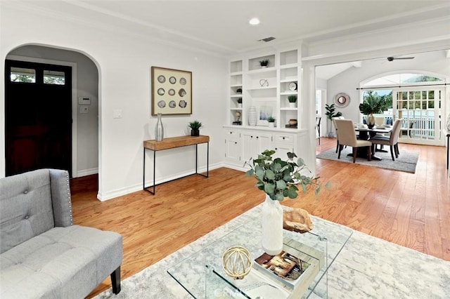 3326 Los Olivos Ln, Glendale, CA 91214 - living room featuring crown molding, arched walkways, light wood-type flooring, ceiling fan, and built in shelves