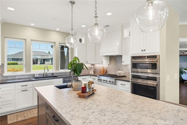 5031 San Juanico Dr, Chico, CA 95973 - kitchen featuring stainless steel appliances, custom range hood, dark wood finished floors, white cabinets, and tasteful backsplash