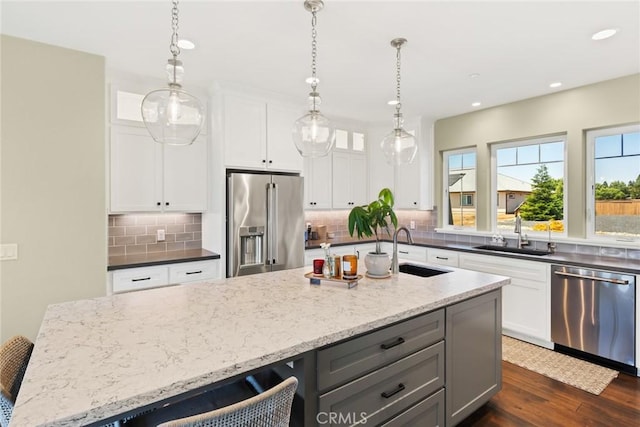 5031 San Juanico Dr, Chico, CA 95973 - kitchen with appliances with stainless steel finishes, decorative backsplash, light stone counters, recessed lighting, and dark wood finished floors