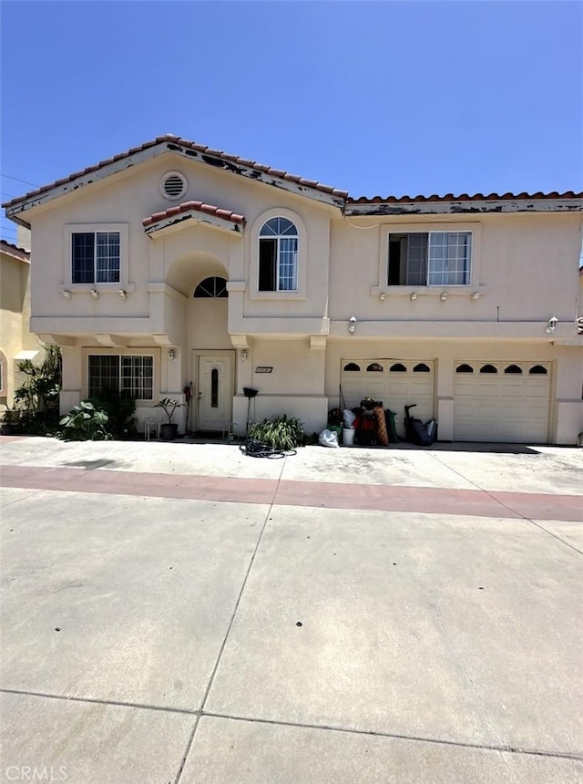 8419 2nd St Unit 2, Paramount, CA 90723 - mediterranean / spanish-style house with stucco siding, an attached garage, concrete driveway, and a tiled roof