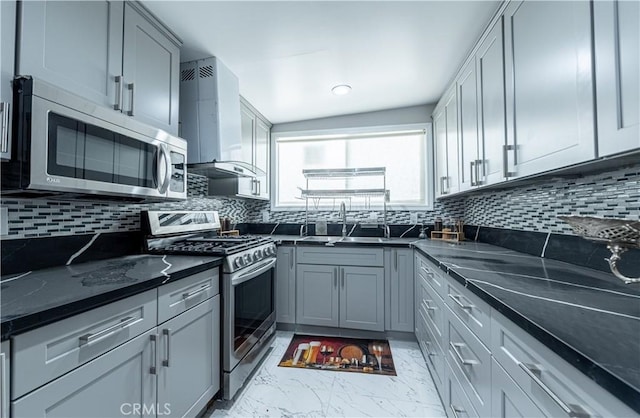 4759 Cochran St, Simi Valley, CA 93063 - kitchen featuring appliances with stainless steel finishes, wall chimney exhaust hood, light marble finish floors, backsplash, and dark stone countertops