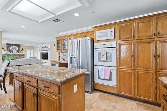 2561 Upper Bay Dr, Oxnard, CA 93036 - kitchen featuring white appliances, brown cabinets, a kitchen island, and recessed lighting