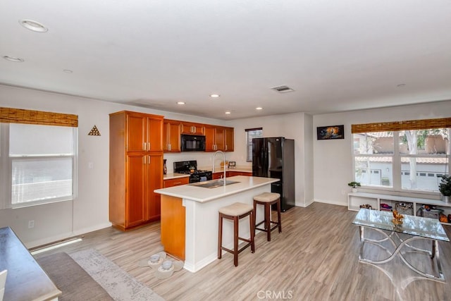 13015 New Hvn, Riverside, CA 92503 - kitchen with black appliances, brown cabinetry, light countertops, light wood-style flooring, and recessed lighting