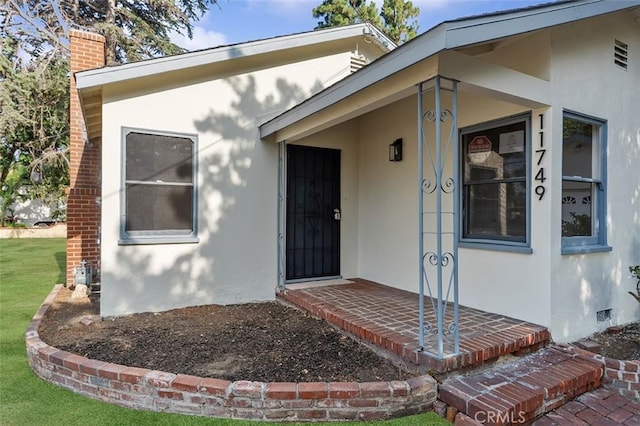 11749 Clarkman St, Santa Fe Springs, CA 90670 - view of exterior entry with stucco siding, a chimney, and a yard