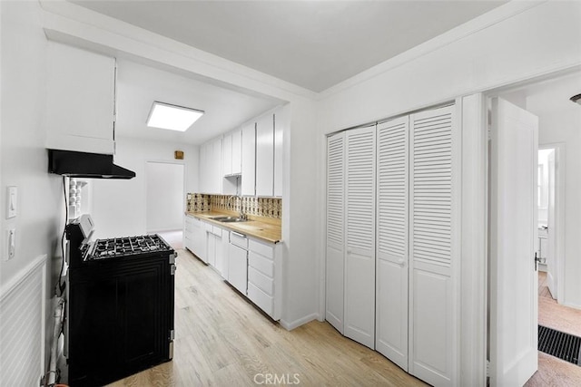 11749 Clarkman St, Santa Fe Springs, CA 90670 - kitchen featuring gas range oven, exhaust hood, light countertops, backsplash, and light wood-type flooring