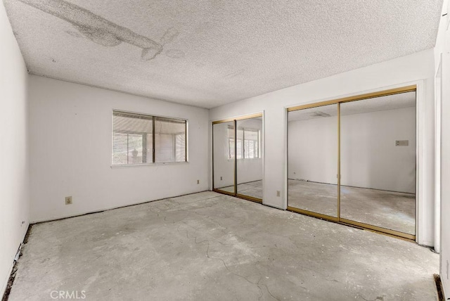 10527 S Wilton Pl, Los Angeles, CA 90047 - unfurnished bedroom featuring multiple closets and a textured ceiling