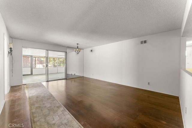 10527 S Wilton Pl, Los Angeles, CA 90047 - empty room featuring hardwood / wood-style flooring, a textured ceiling, and a chandelier
