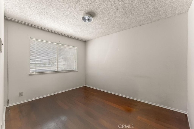 10527 S Wilton Pl, Los Angeles, CA 90047 - empty room featuring dark wood finished floors and a textured ceiling