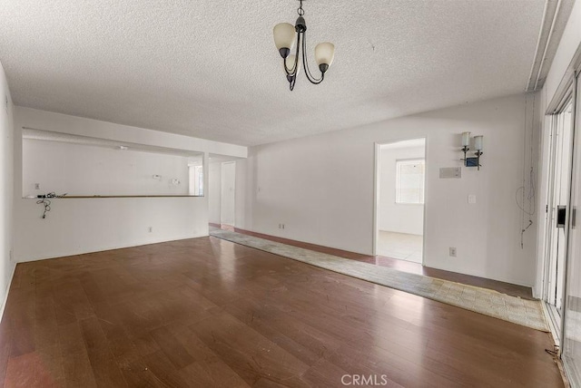 10527 S Wilton Pl, Los Angeles, CA 90047 - empty room with wood finished floors, a textured ceiling, and a chandelier