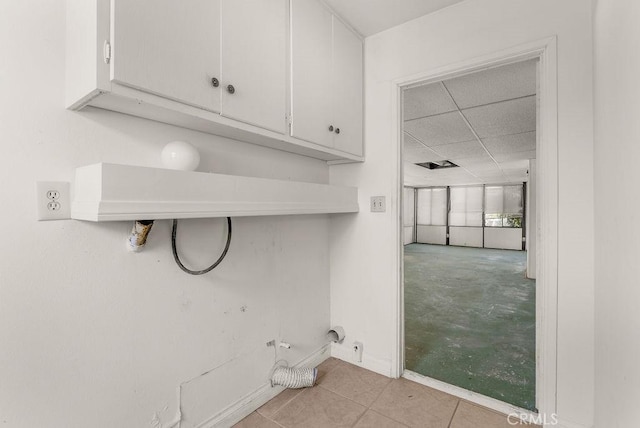 10527 S Wilton Pl, Los Angeles, CA 90047 - washroom featuring cabinet space and tile patterned flooring