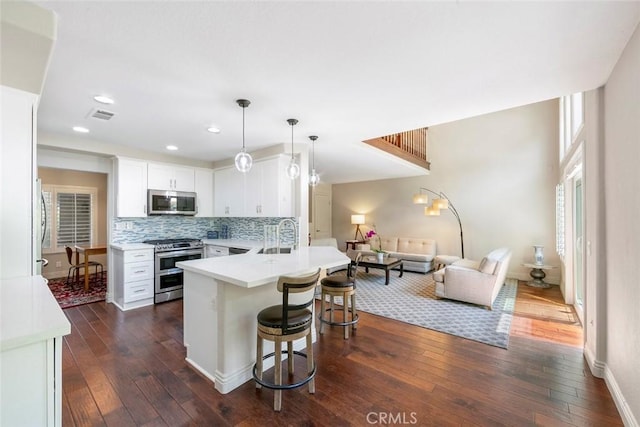29411 Port Royal Way, Laguna Niguel, CA 92677 - kitchen featuring stainless steel appliances, a kitchen bar, open floor plan, dark wood-style floors, and recessed lighting