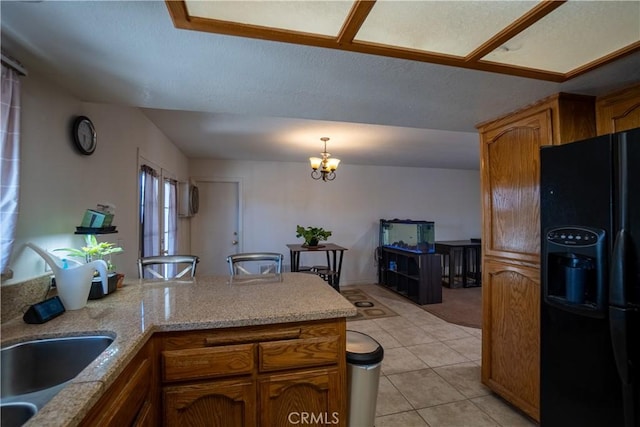 7681 Newhall Ave, Hesperia, CA 92345 - kitchen featuring black fridge with ice dispenser, a peninsula, brown cabinets, decorative light fixtures, and light tile patterned flooring