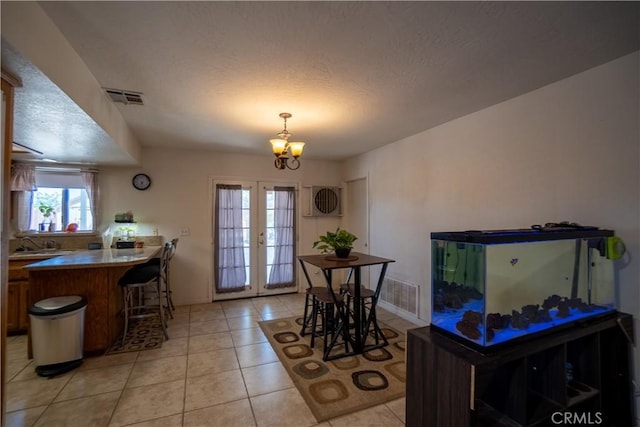 7681 Newhall Ave, Hesperia, CA 92345 - dining area featuring a chandelier, light tile patterned floors, and a textured ceiling