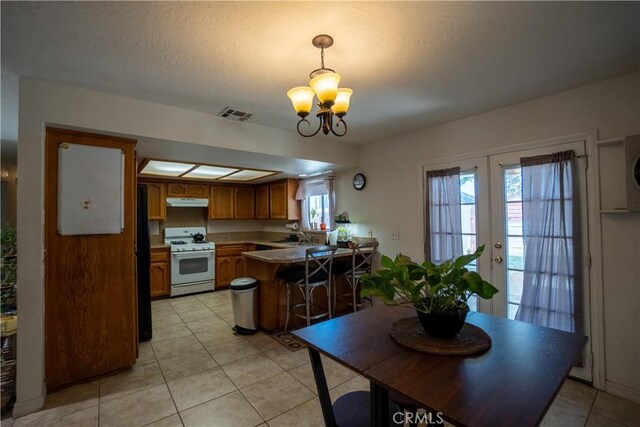 7681 Newhall Ave, Hesperia, CA 92345 - dining area with a chandelier, light tile patterned floors, and french doors