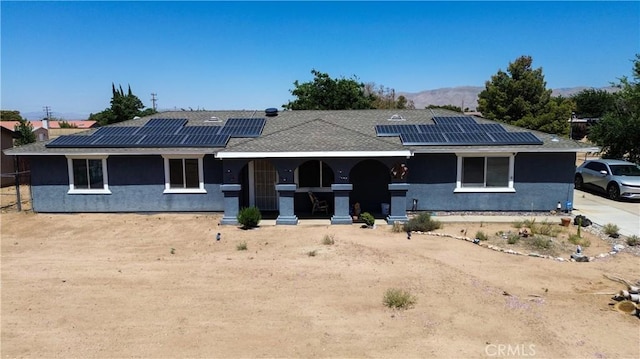 7681 Newhall Ave, Hesperia, CA 92345 - view of front of home featuring covered porch, stucco siding, solar panels, and a mountain view