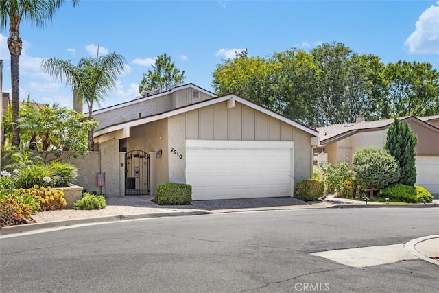 2910 Pinewood Ct, Fullerton, CA 92835 - view of front of house featuring a garage, driveway, and board and batten siding