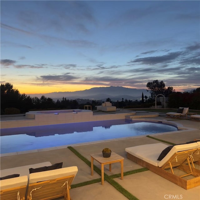1257 Fetlock Way, Riverside, CA 92506 - pool at dusk featuring a mountain view, a patio area, and an infinity pool