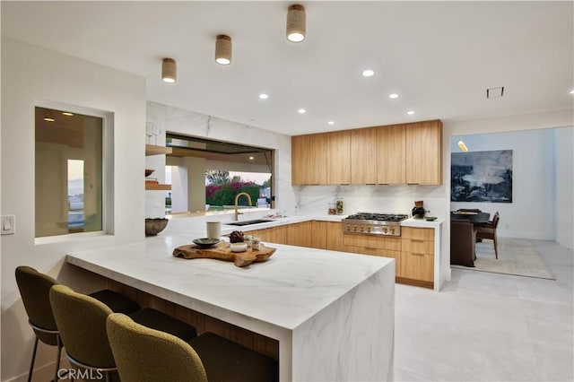 1257 Fetlock Way, Riverside, CA 92506 - kitchen with modern cabinets, a peninsula, a kitchen breakfast bar, stainless steel gas stovetop, and recessed lighting