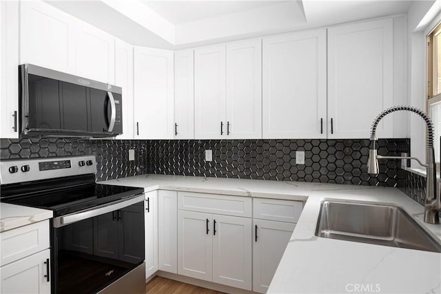 5910 Rancho Mission Rd Unit 27, San Diego, CA 92108 - kitchen with stainless steel appliances, white cabinetry, and decorative backsplash